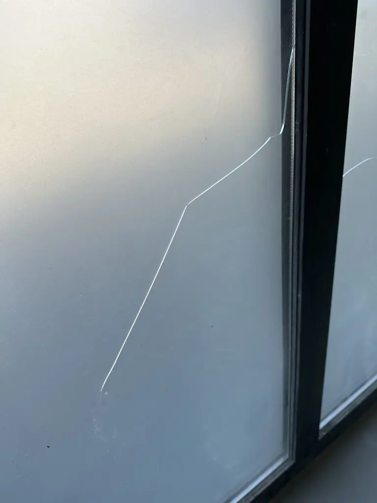 Exemple réel de casse thermique sur fenêtre double vitrage: contraintes différentielles, microfissures et rupture en étoile.